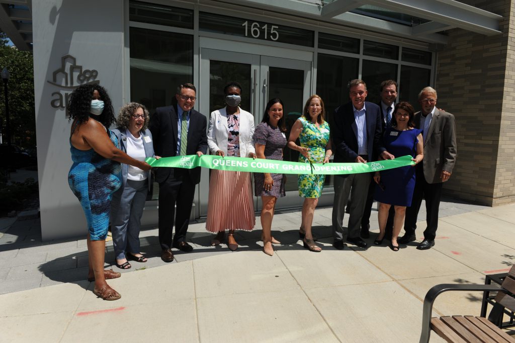 APAH leaders join local, state and federal government representatives to cut the grand opening ribbon at Queens Court in June, 2021